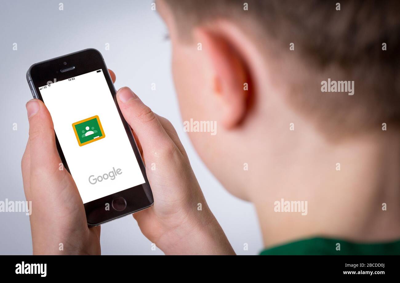 A teenager using the google classroom app on a mobile phone Stock Photo