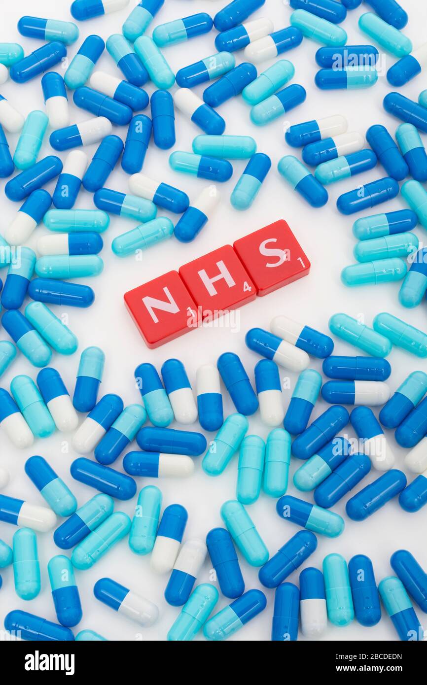 NHS letters tiles & assorted blue pills. Metaphor NHS in Covid 19 pandemic, NHS heroes, NHS prescriptions, UK National Health Service, medicine in UK Stock Photo