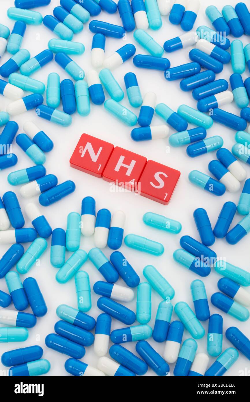 NHS letters tiles & assorted blue pills. Metaphor NHS in Covid 19 pandemic, NHS heroes, NHS prescriptions, UK National Health Service, medicine in UK Stock Photo