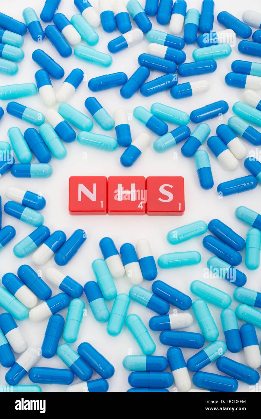 NHS letters tiles & assorted blue pills. Metaphor NHS in Covid 19 pandemic, NHS heroes, NHS prescriptions, UK National Health Service, medicine in UK Stock Photo