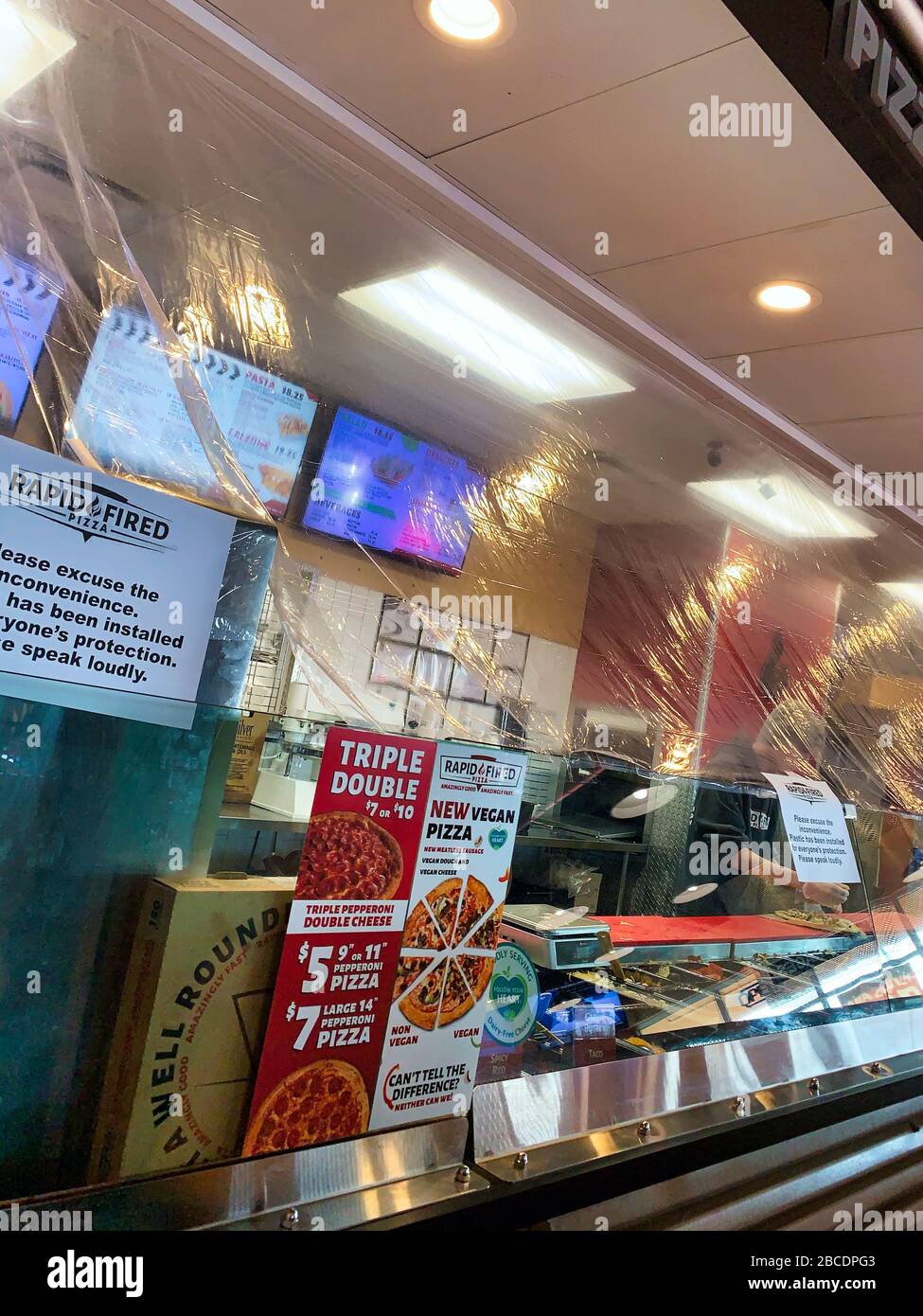 Dayton, OH- April 3, 2020: Plastic installed over food preparation area at rapid fired pizza in Beavercreek. Sign stating this is for protection due t Stock Photo