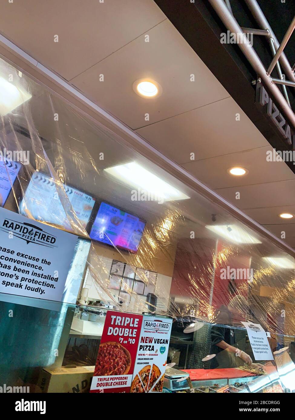 Dayton, OH- April 3, 2020: Plastic installed over food preparation area at rapid fired pizza in Beavercreek. Sign stating this is for protection due t Stock Photo