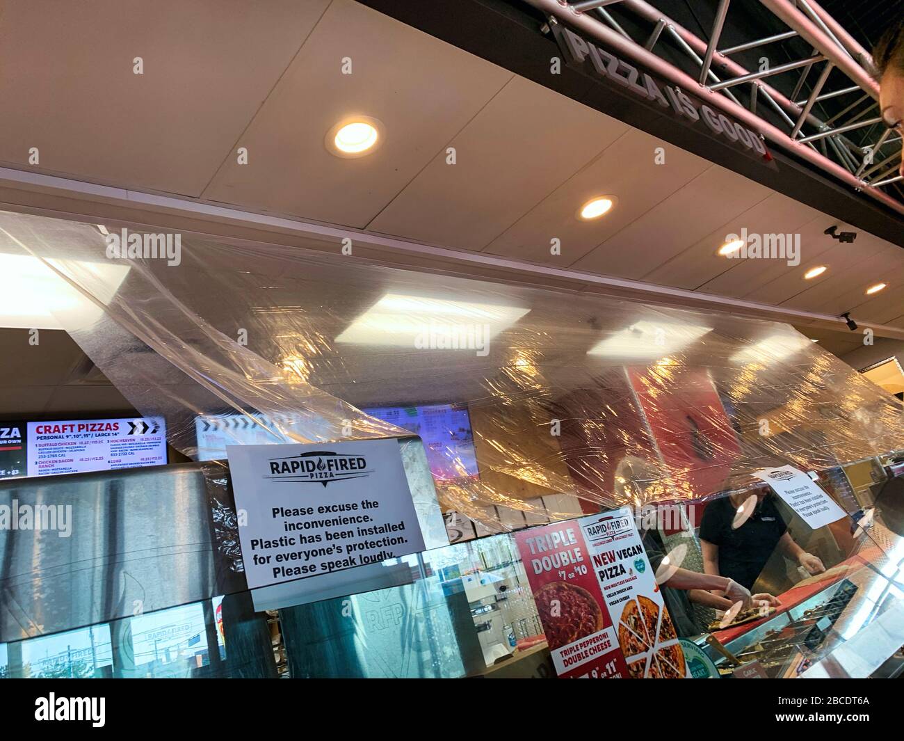 Dayton, OH- April 3, 2020: Plastic installed over food preparation area at rapid fired pizza in Beavercreek. Sign stating this is for protection due t Stock Photo