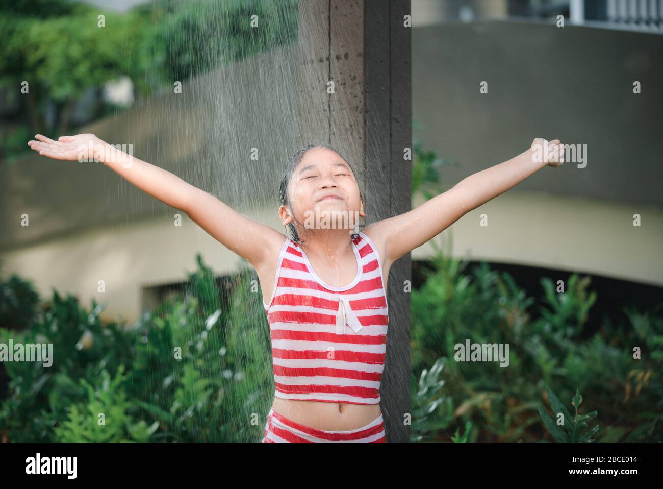 Happy cute girl taking shower before swimming, healthy and recreation