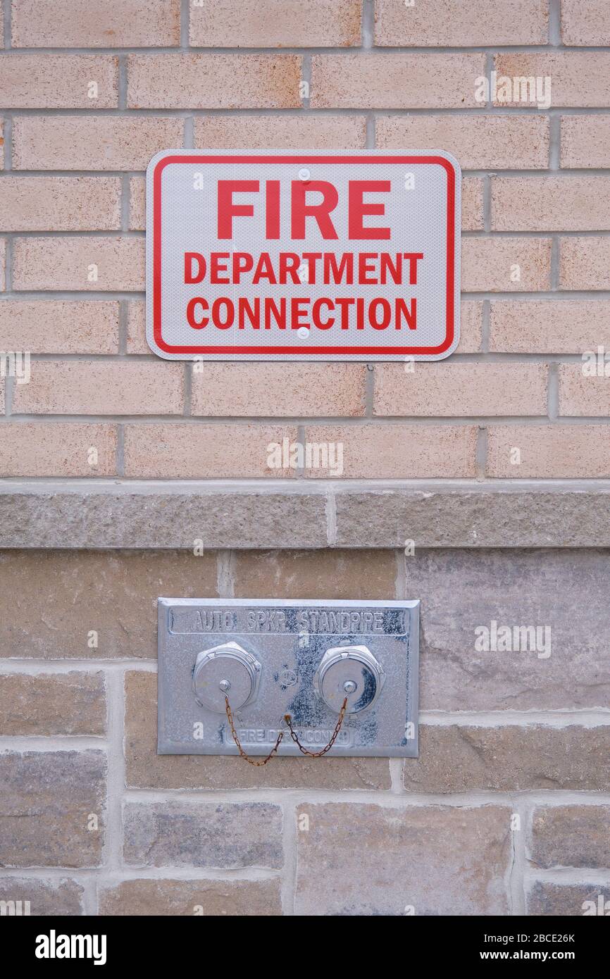Connection that allows fire fighters to supply water to the sprinkler system of a commercial building in the event of an emergency. Stock Photo