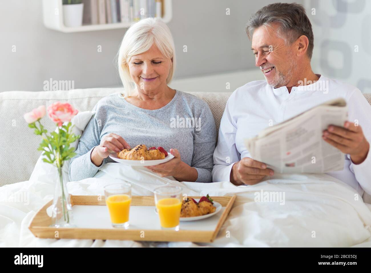 Senior couple enjoying breakfast in bed Stock Photo