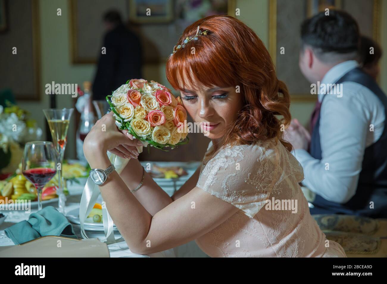 bride sitting smiling brightly in her hand holding a beautiful bouquet ...