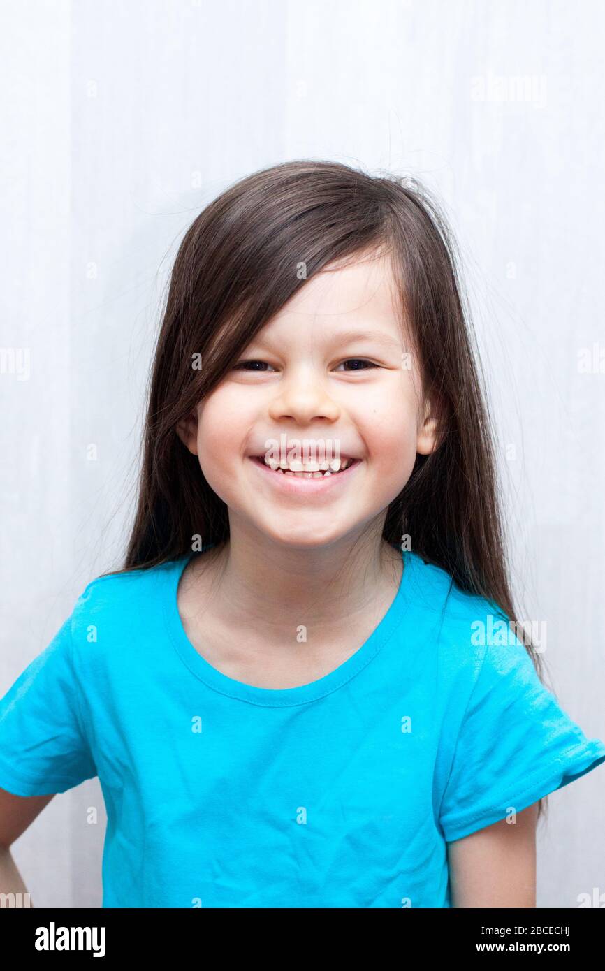 Portrait of cute smiling european child girl with long brown hair. Stock Photo