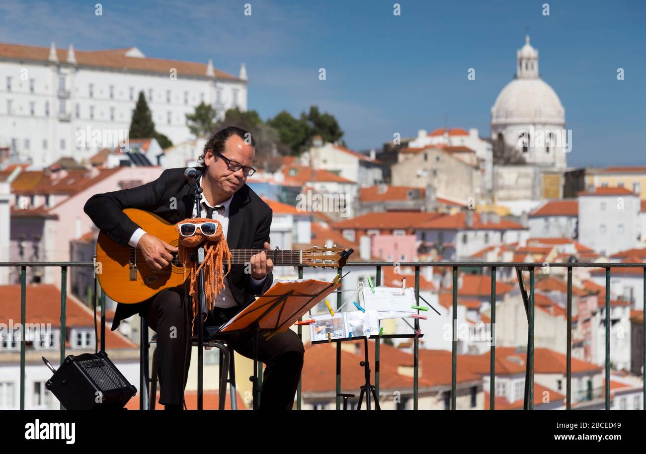 Busker playing guitar at Miradouro das Portas do Sol, Lisbon Stock Photo