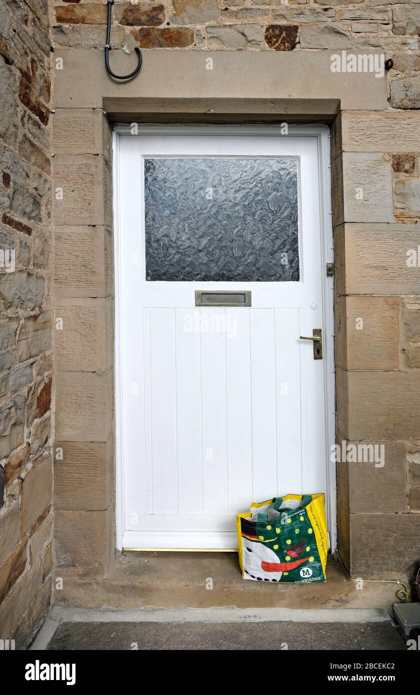 Shopping Left by the Door of a House for People who are in Isolation Due to the Coronavirus (Covid-19), England, UK Stock Photo