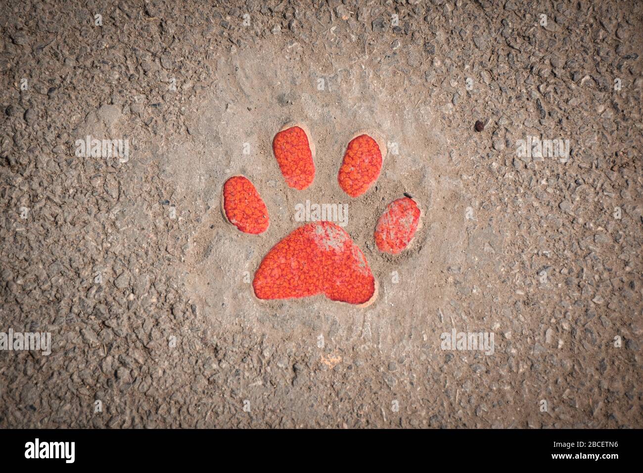 Ceramic orange colored paw shaped sign showing the walking pathway in the garden of the Tao Hong Tai Ceramics Factory in Ratchaburi, Thailand Stock Photo