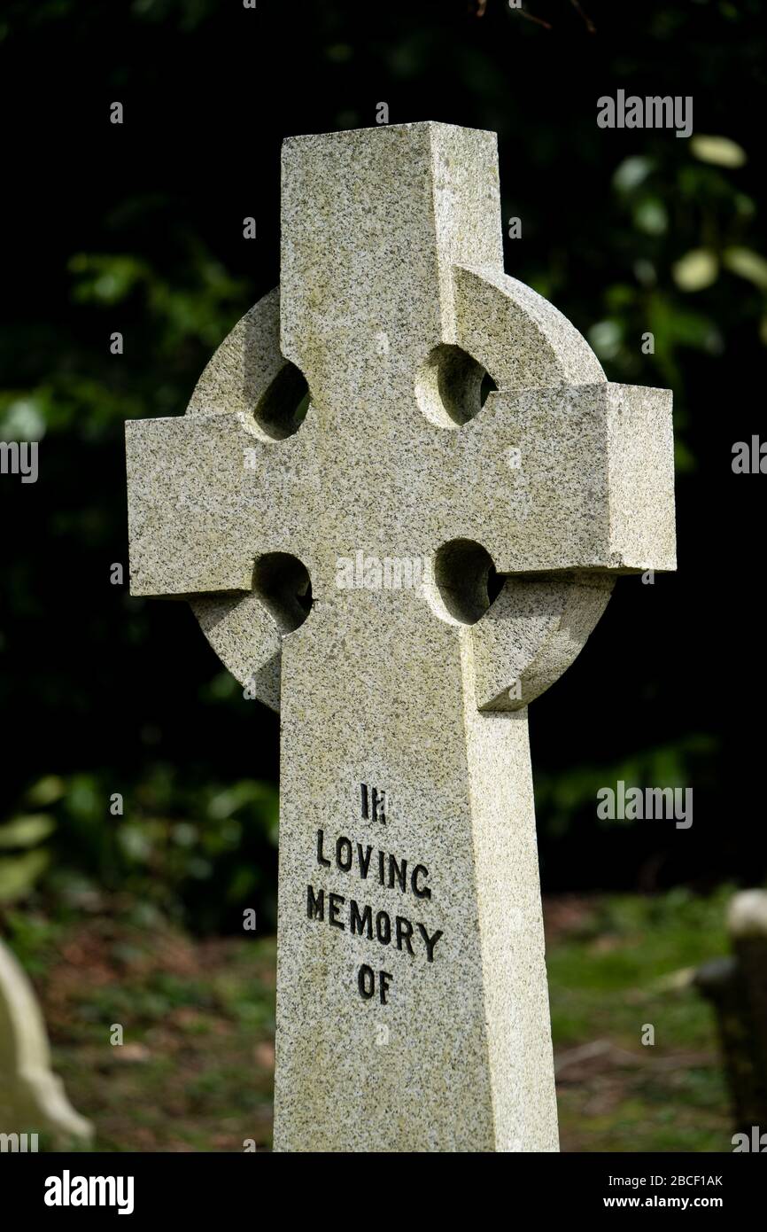 A Christian cross gravestone in a graveyard, UK Stock Photo