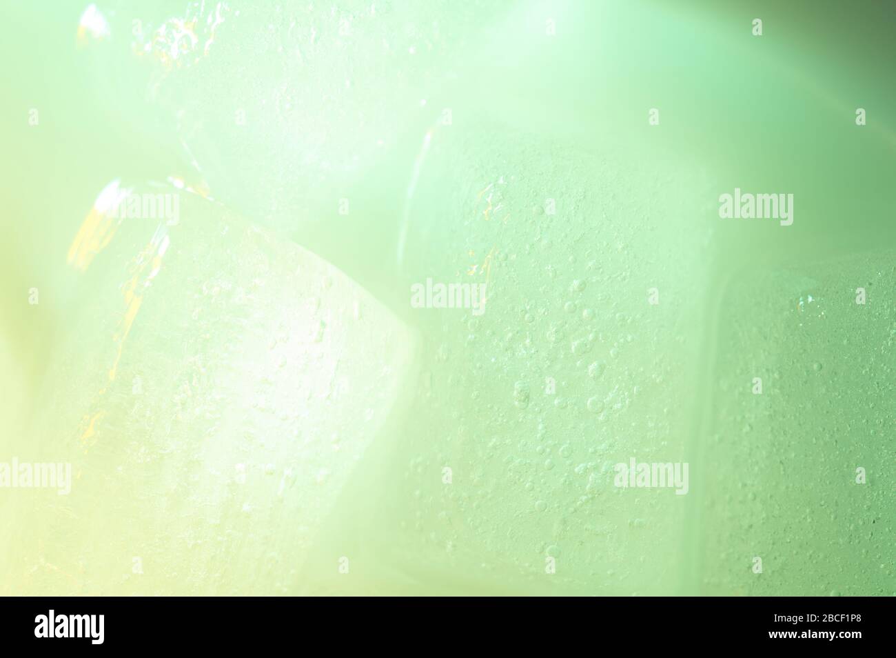 Glowing green ice cube abstract background close up view Stock Photo