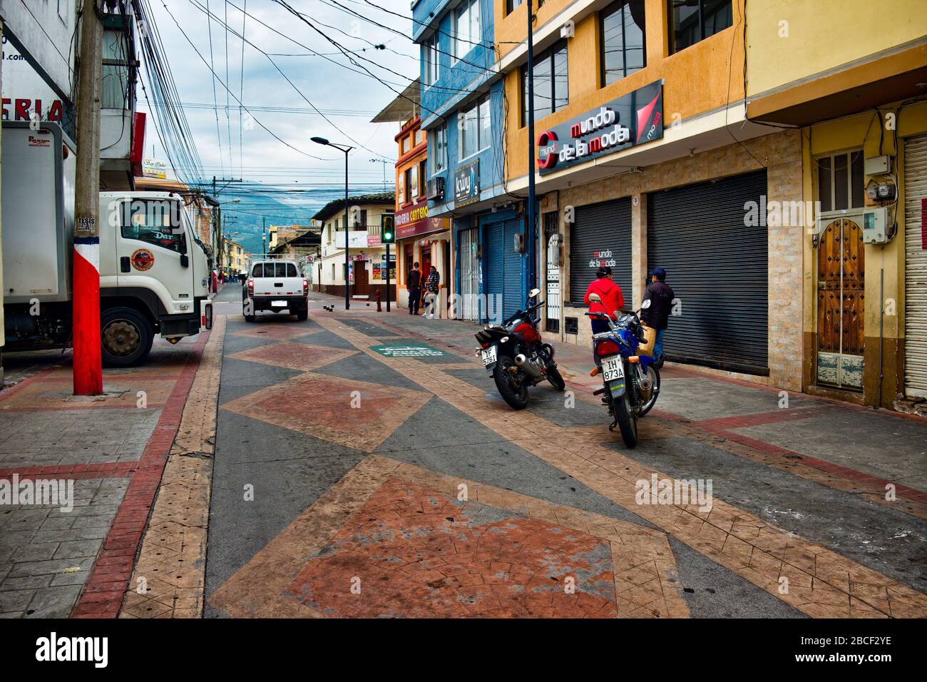 Coronavirus Cotacachi trip 6of11: empty brick-paved street shuttered shops Andes range in background village canton or pueblo in Ecuador S. America Stock Photo