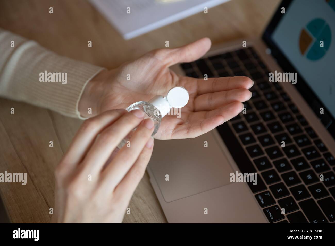 Woman applying sanitizer disinfecting hands, killing coronavirus grippe flu bacterium. Stock Photo