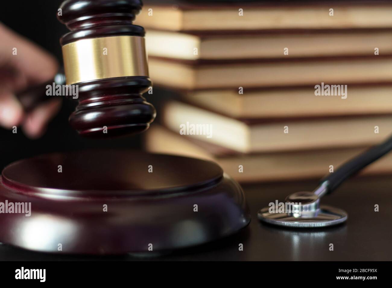 Judge hitting Gavel on block with medical stethoscope and law books on the background Stock Photo