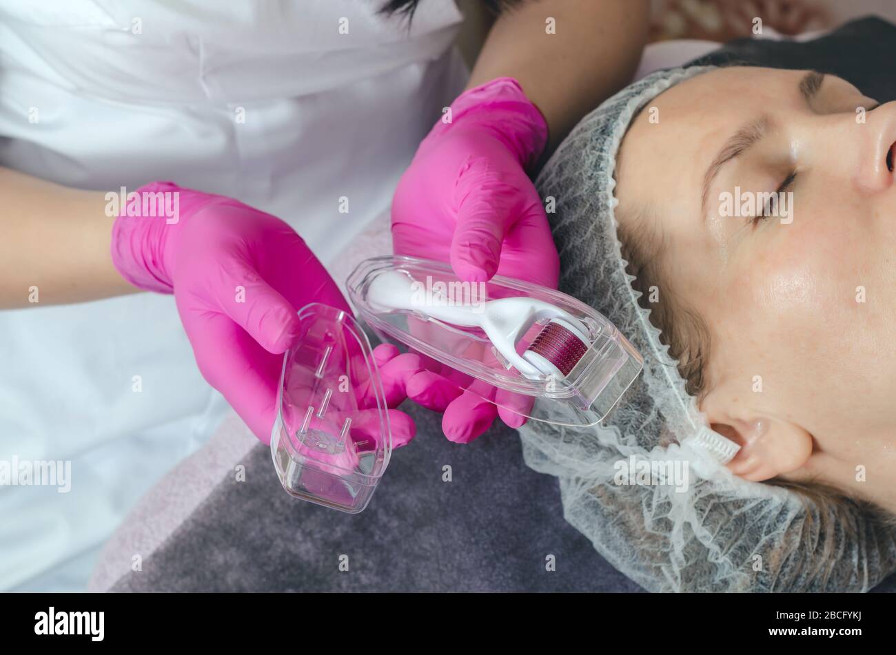 Cosmetologist shows mesoscooter close-up. Carrying out anti-aging treatments in spa Stock Photo