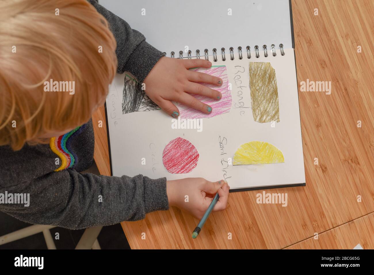 Child learning at home. Pre school age child learning about shapes and hand writing Stock Photo