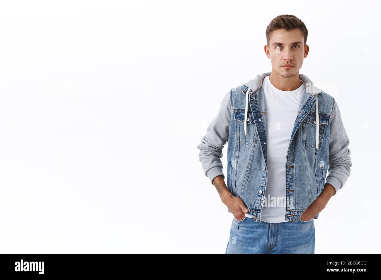 Portrait of young serious-looking, confident handsome gay man with blond  hair, bristle, hold hands in jeans pockets and looking camera, waiting for  Stock Photo - Alamy