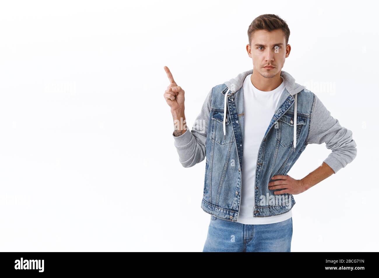 Serious-looking handsome gay man with blond hair, pointing finger up and  look camera focused, insist on clicking link, suggest product, showing way  to Stock Photo - Alamy