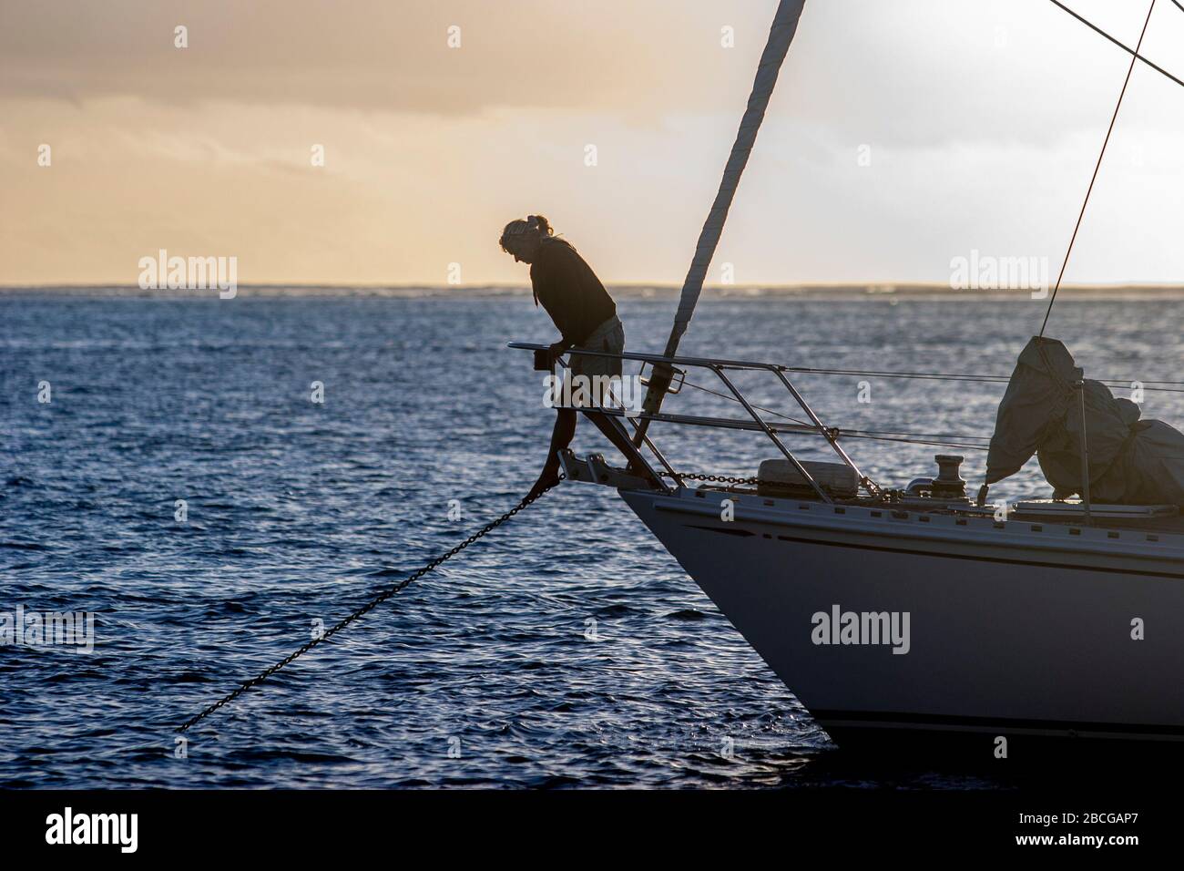young woman checking the anchor chain of a sailing yacht at the