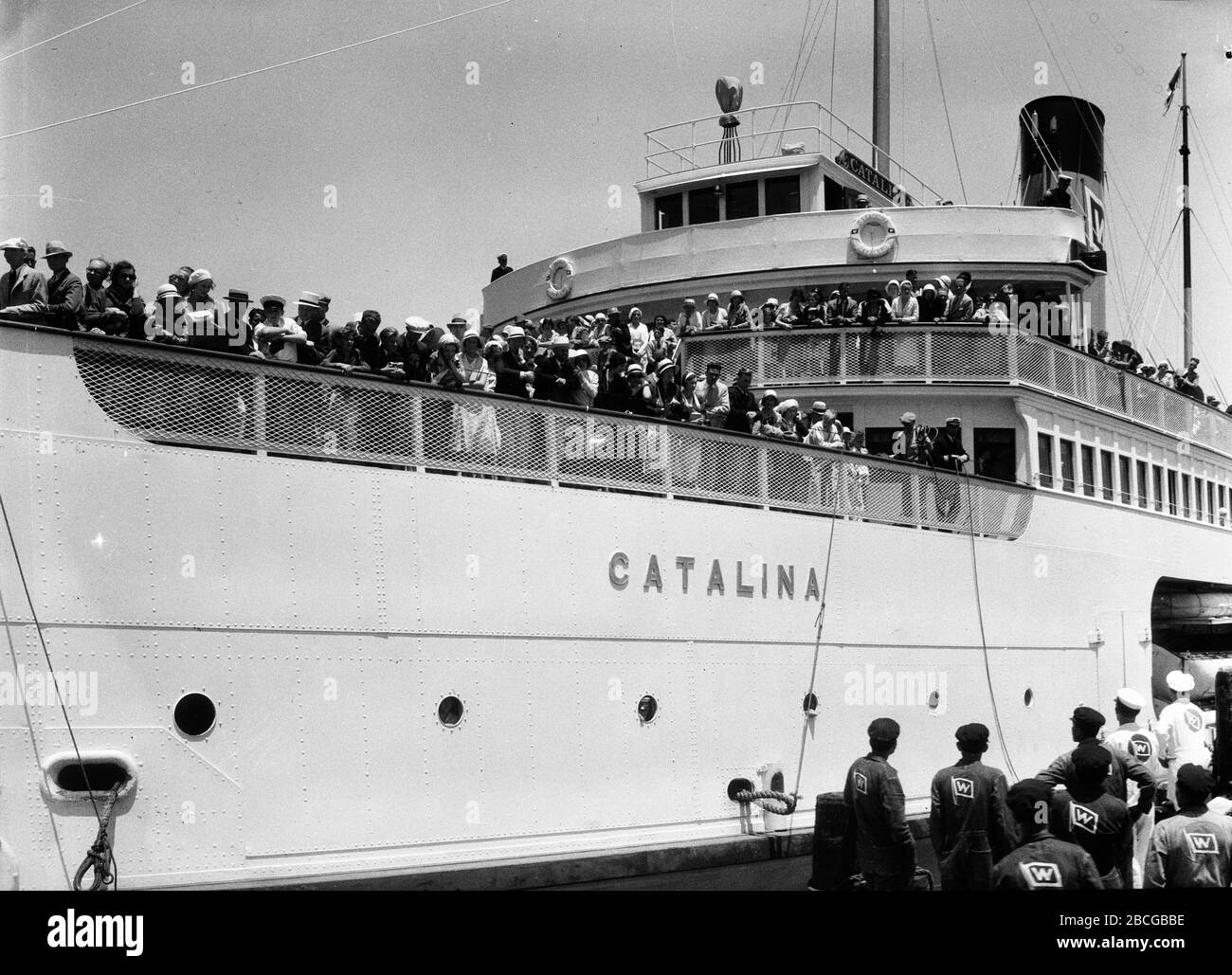 Passengers watch from decks of the SS Catalina, also known as The Great White Steamer, docked in Avalon, Santa Catalina Island, California, 1931. Photography by Burton Holmes. Stock Photo