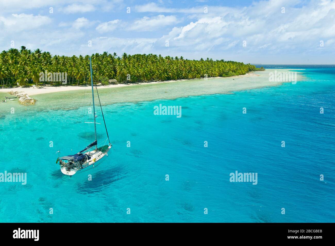 Sailing yacht anchoring in the shallow waters of suwarrow atoll, cook
