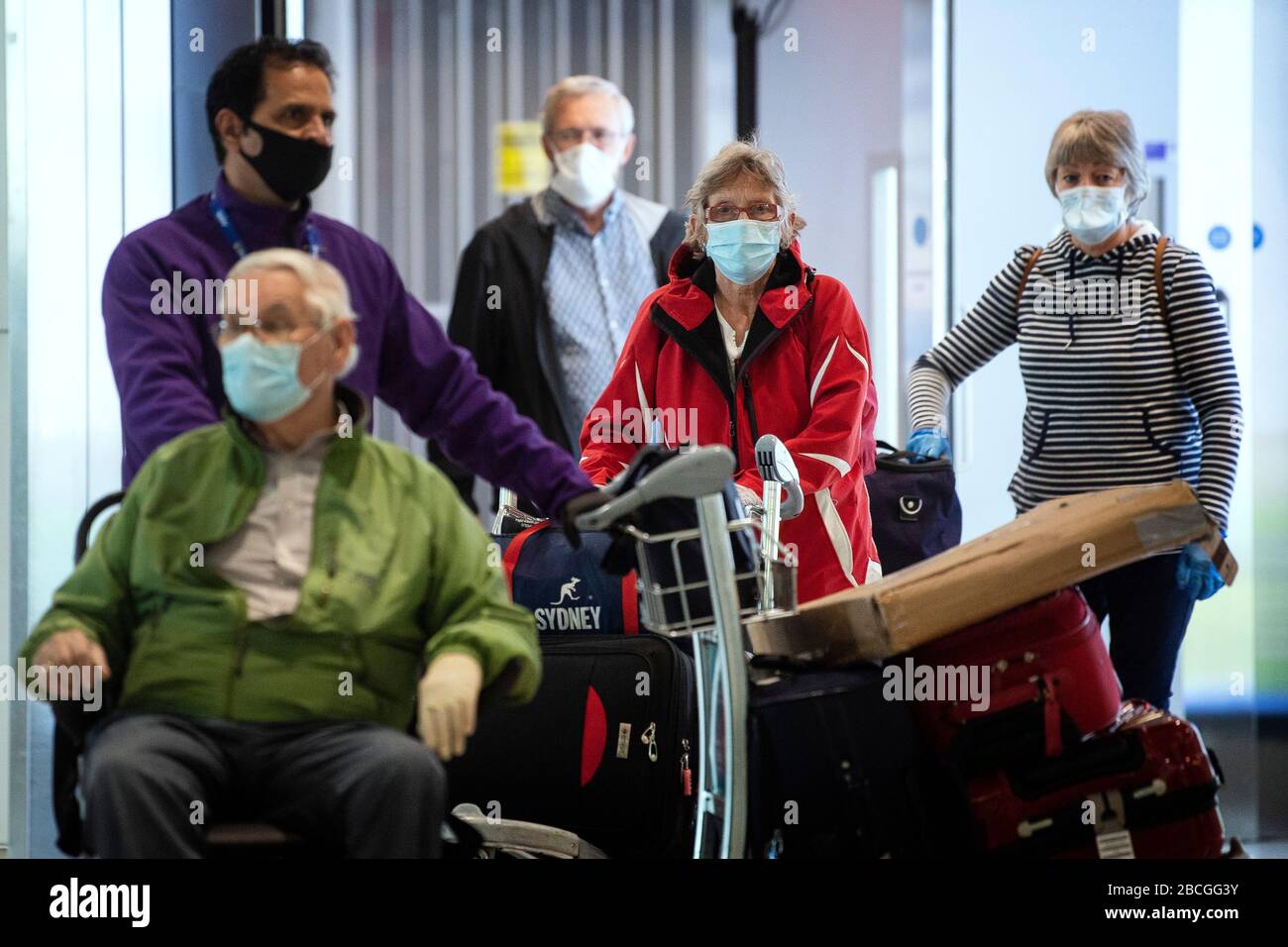 Passengers from the Holland America Line ship Zaandam walk through arrivals in Terminal 2 at Heathrow Airport in London, after flying back on a repatriation flight from Florida. Stock Photo