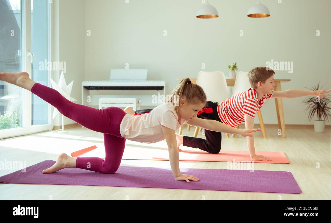Happy siblings children making yoga at home dueing coronavirus ...