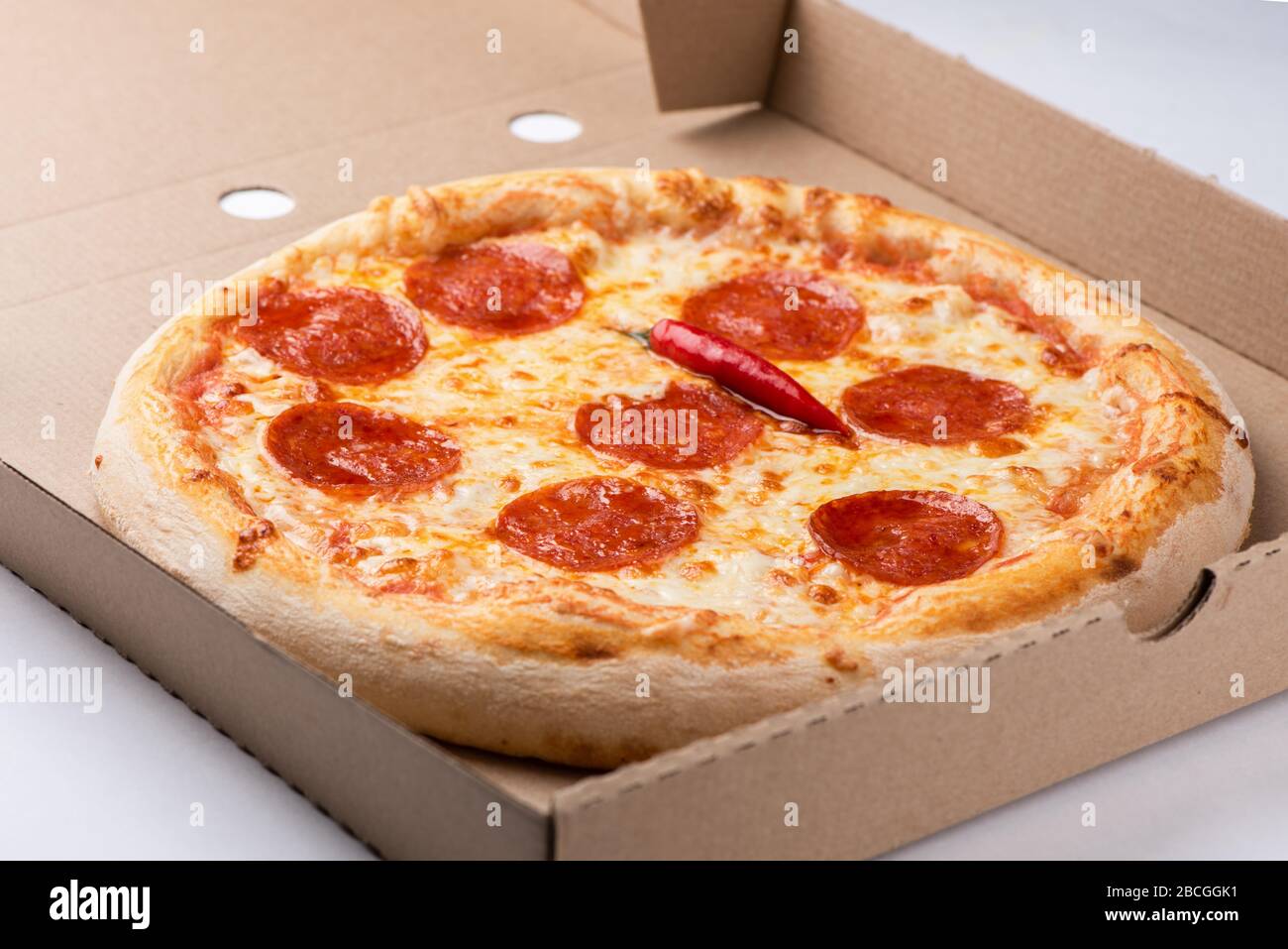 Pizza inside open box on tall stack of delivery boxes close up Stock Photo
