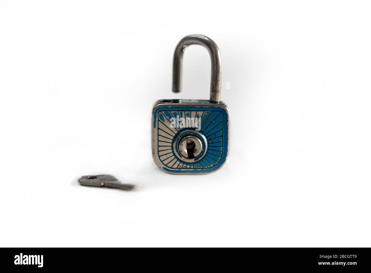 An open old padlock with a key, white background. Stock Photo