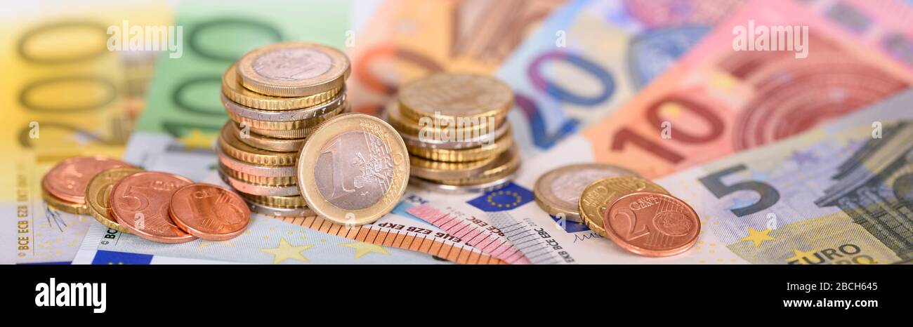 Many Euro banknotes and coins of european currency Stock Photo
