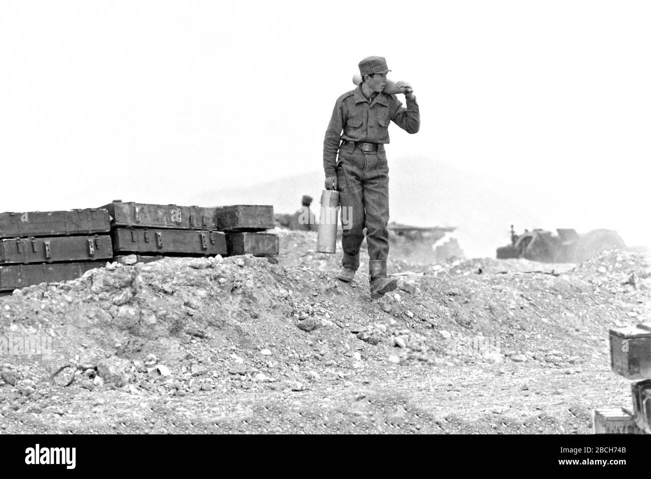An Afghan soldier carries artillery rounds for a Soviet-made 122mm cannon at the Pagaman forward operating post May 1, 1989 in Pagaman, Afghanistan. The base protects a main entry point into the capital Kabul and is less than a mile from the Afghan mujahideen fighters front lines. Stock Photo
