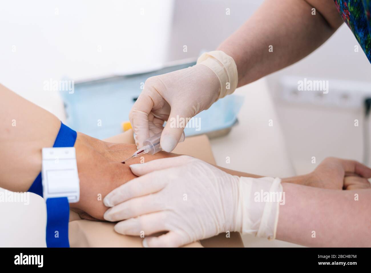 Closeup pricking needle syringe in blood sample for blood testing