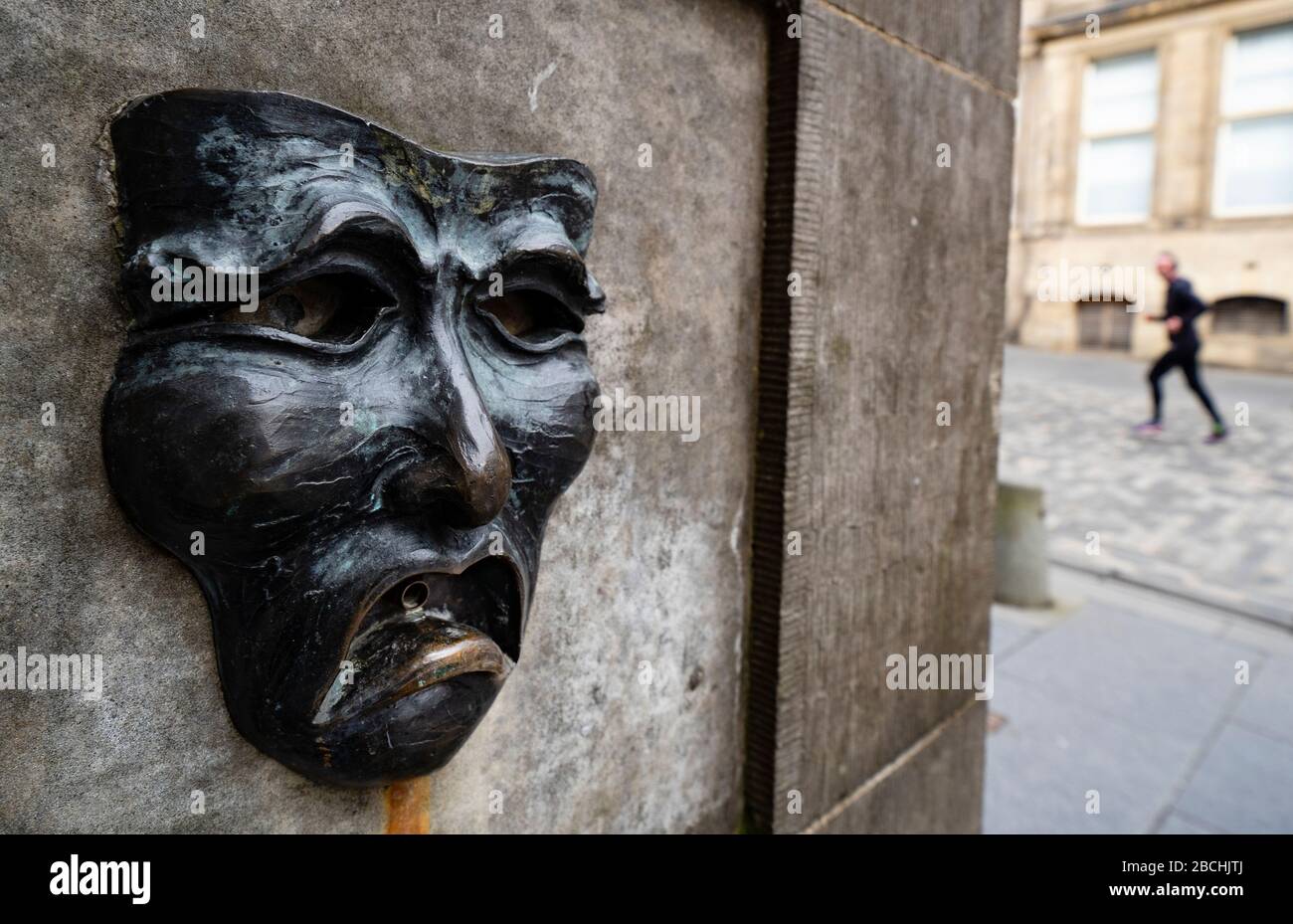 Theatrical mask bronze relief with sad face on High Street Wellhead on the Royal Mile in Edinburgh, Scotland, UK to indicate sadness of cancellation of the Edinburgh Fringe festival 2020. Stock Photo