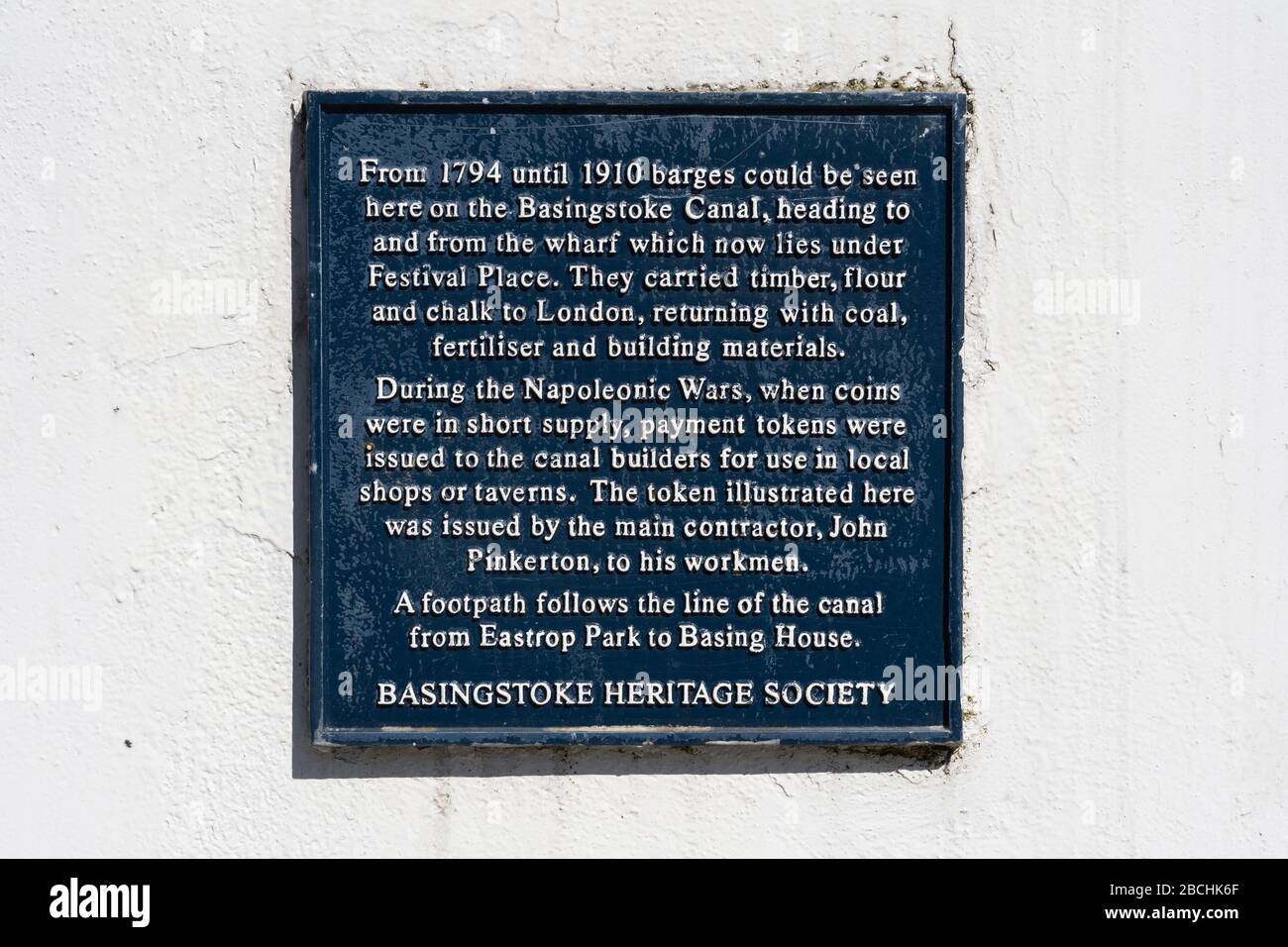 A plaque describing offloading of barges on Basingstoke canal in the past - Basingstoke Heritage Society, UK. The Basingstoke section has been lost Stock Photo
