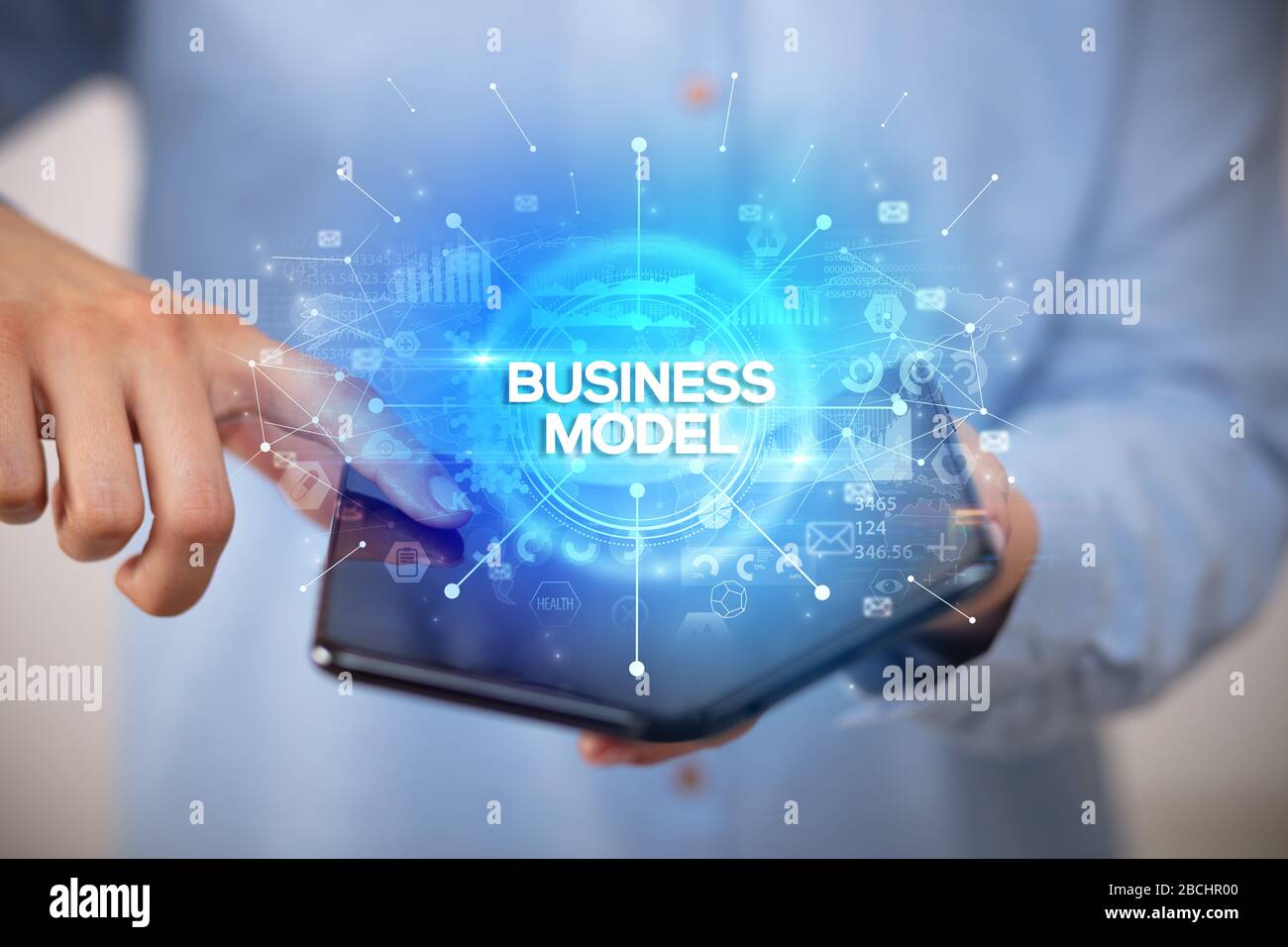Businessman holding a foldable smartphone with BUSINESS MODEL inscription, new business concept Stock Photo