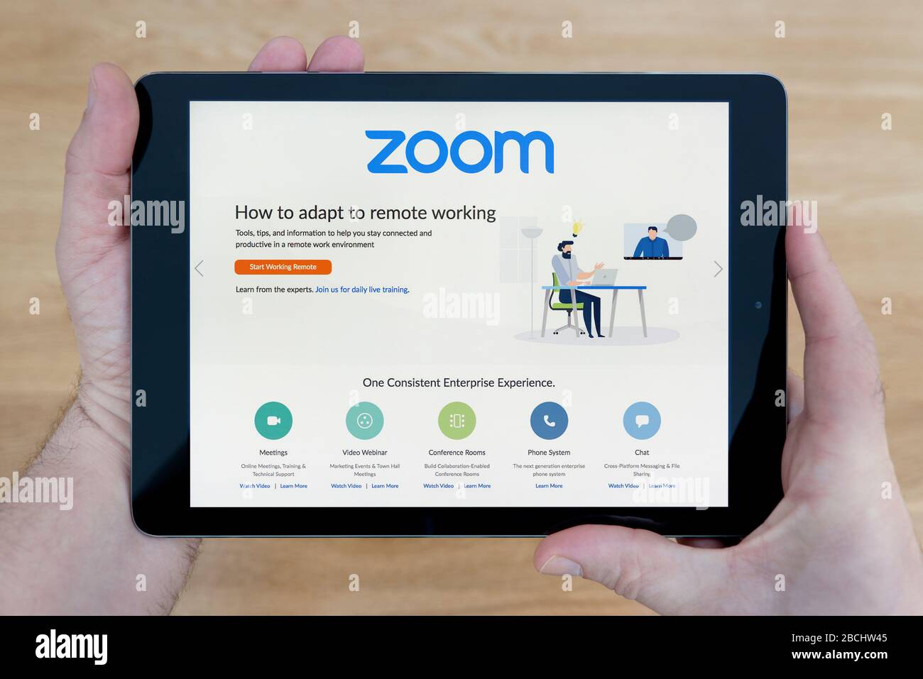 The website of Zoom video conferencing is seen on an iPad tablet, which is being held (Editorial use only). Stock Photo