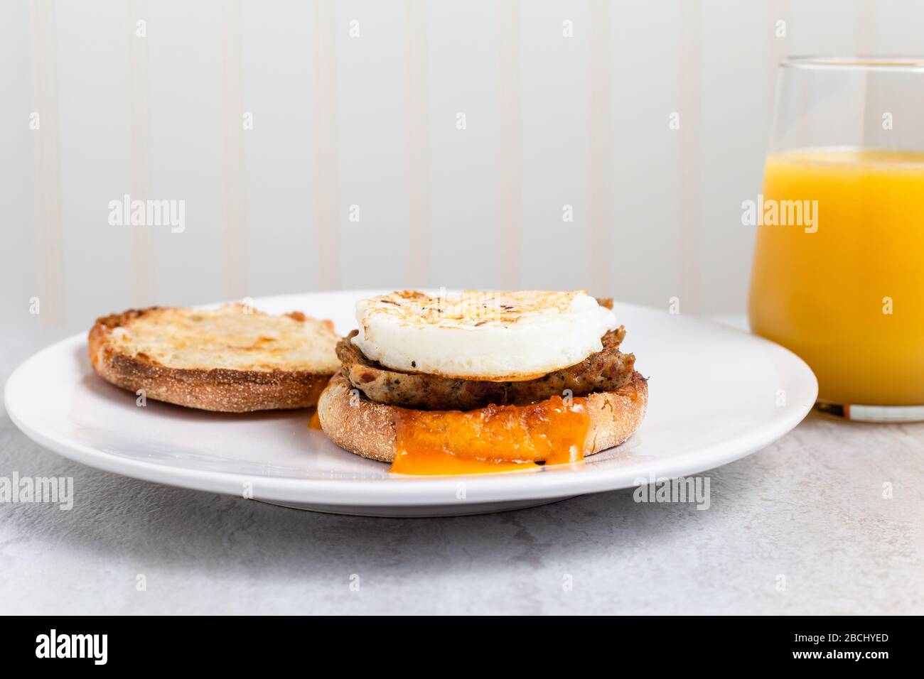 Sausage, egg and cheese breakfast sandwich with orange juice Stock