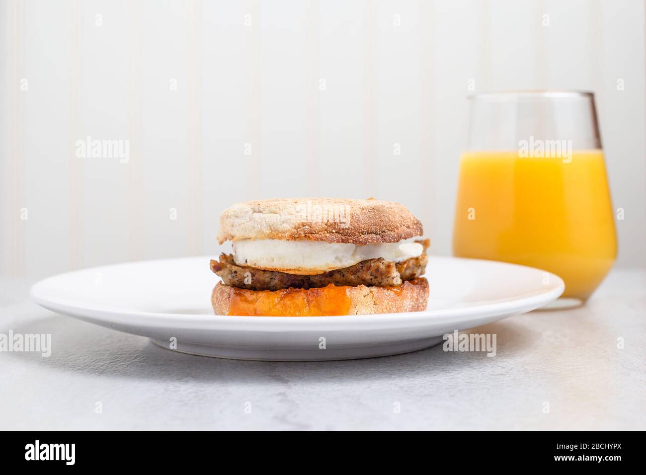 Sausage, egg and cheese breakfast sandwich with orange juice Stock