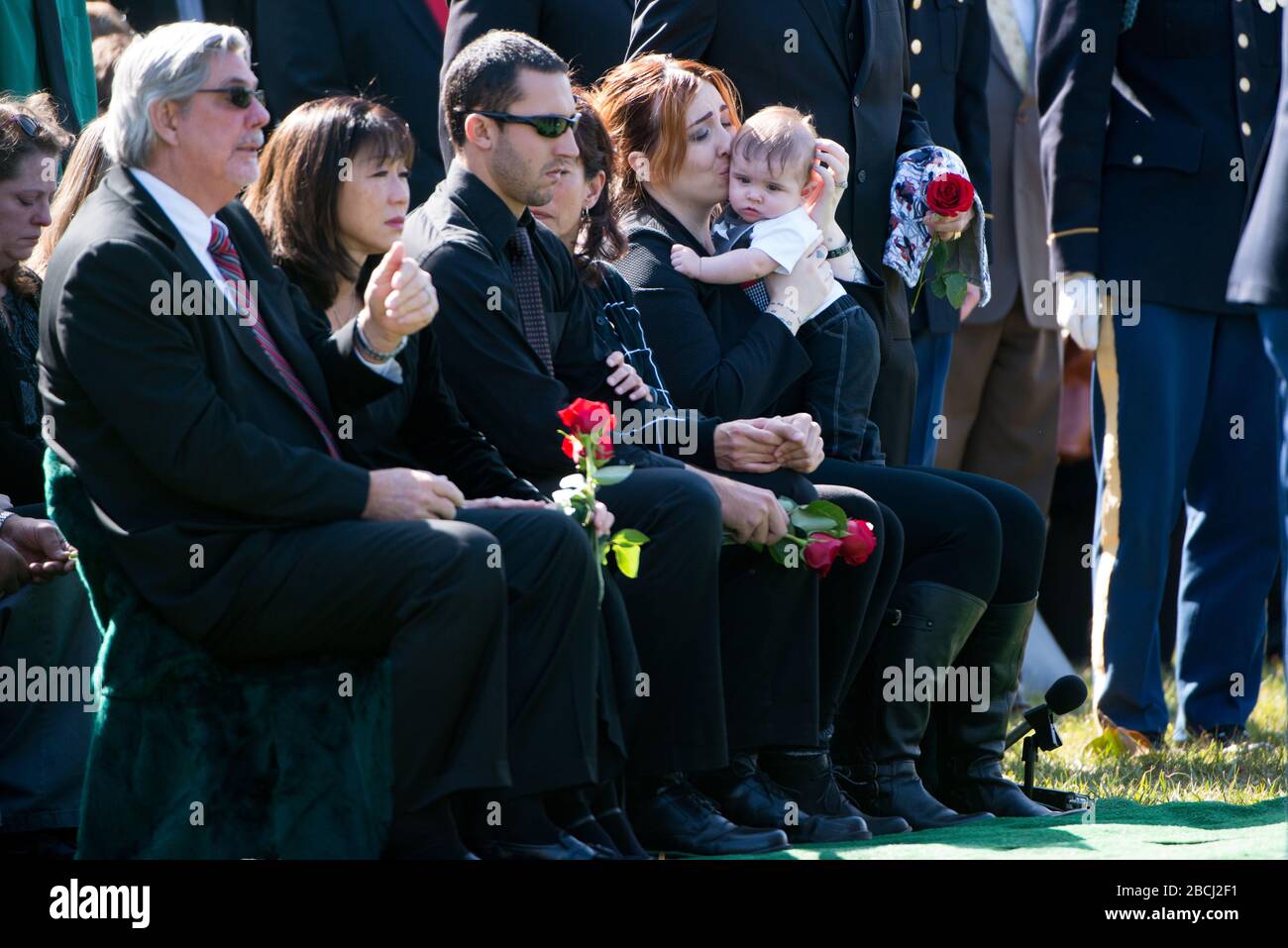 'Alexandra D. McClintock, second from right, kisses her son Declan during the graveside service of her husband, U.S. Army Sgt. First Class Matthew Q. McClintock, in Section 60 of Arlington National Cemetery, March 7, 2016, in Arlington, Va. McClintock was killed in action Jan. 5, 2016, in Afghanistan. (U.S. Army photo by Rachel Larue/Arlington National Cemetery/released); 7 March 2016, 14:47; Graveside service for U.S. Army Sgt First Class Matthew Q. McClintock takes place in Section 60 of Arlington National Cemetery; Arlington National Cemetery; ' Stock Photo