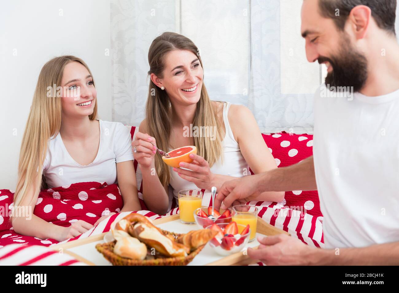 Family having breakfast in bed Stock Photo