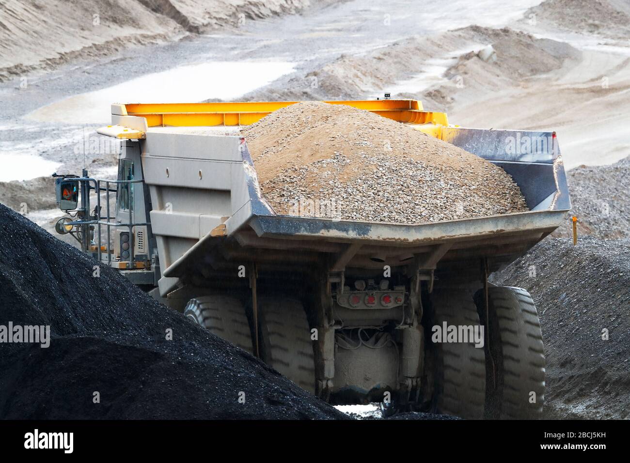 Komatsu HD 605 dump truck with a full load of crushed stone to the storage area at Coldstone Quarry Greenhow in the Nidderdale area of North Yorkshire Stock Photo