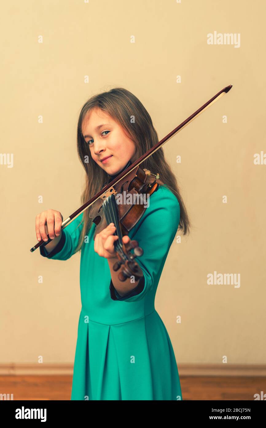 cute girl in a blue dress with a violin. toned. vertical photo Stock