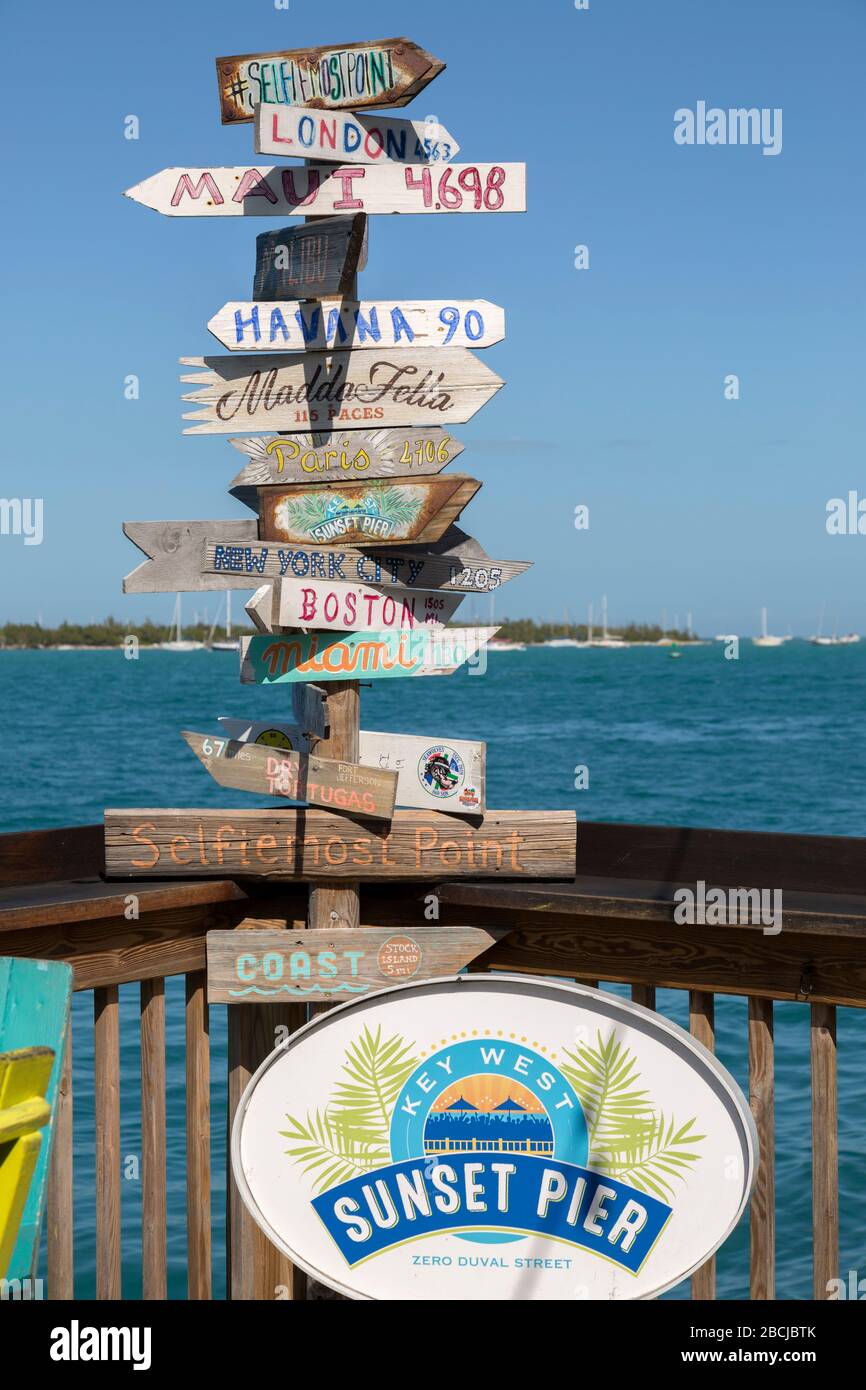 Popular direction sign at the equally popular Sunset Pier Bar on Key West,  Florida, USA Stock Photo - Alamy
