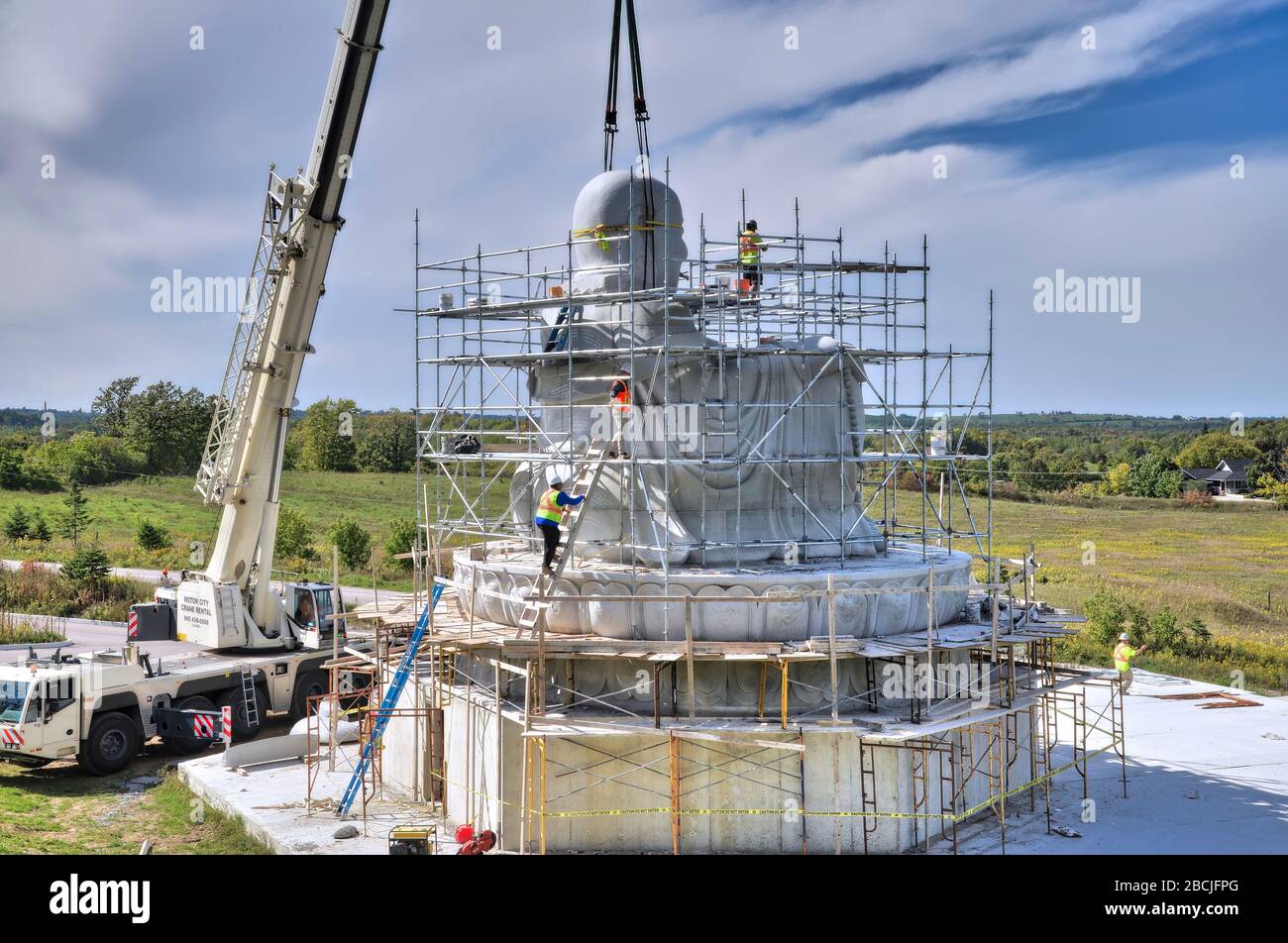 Aerial view of the building of the stone statue by crane truck in the building of Maitreya Buddha. Stock Photo