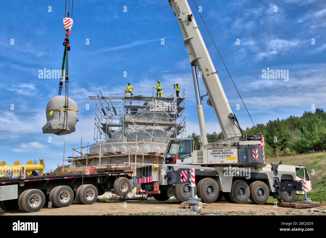 The construction of the stone statue by crane truck in the building of Maitreya Buddha. Stock Photo