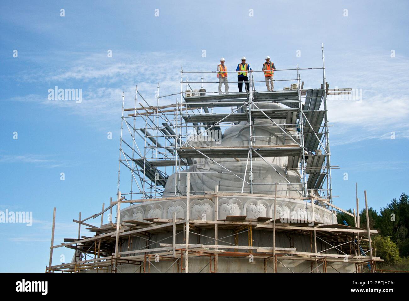 Bethany, Ontario, Canada / 09-28-2016: Low angle view of the construction workers on the scaffold in the building of the stone statue of Maitreya Bud Stock Photo