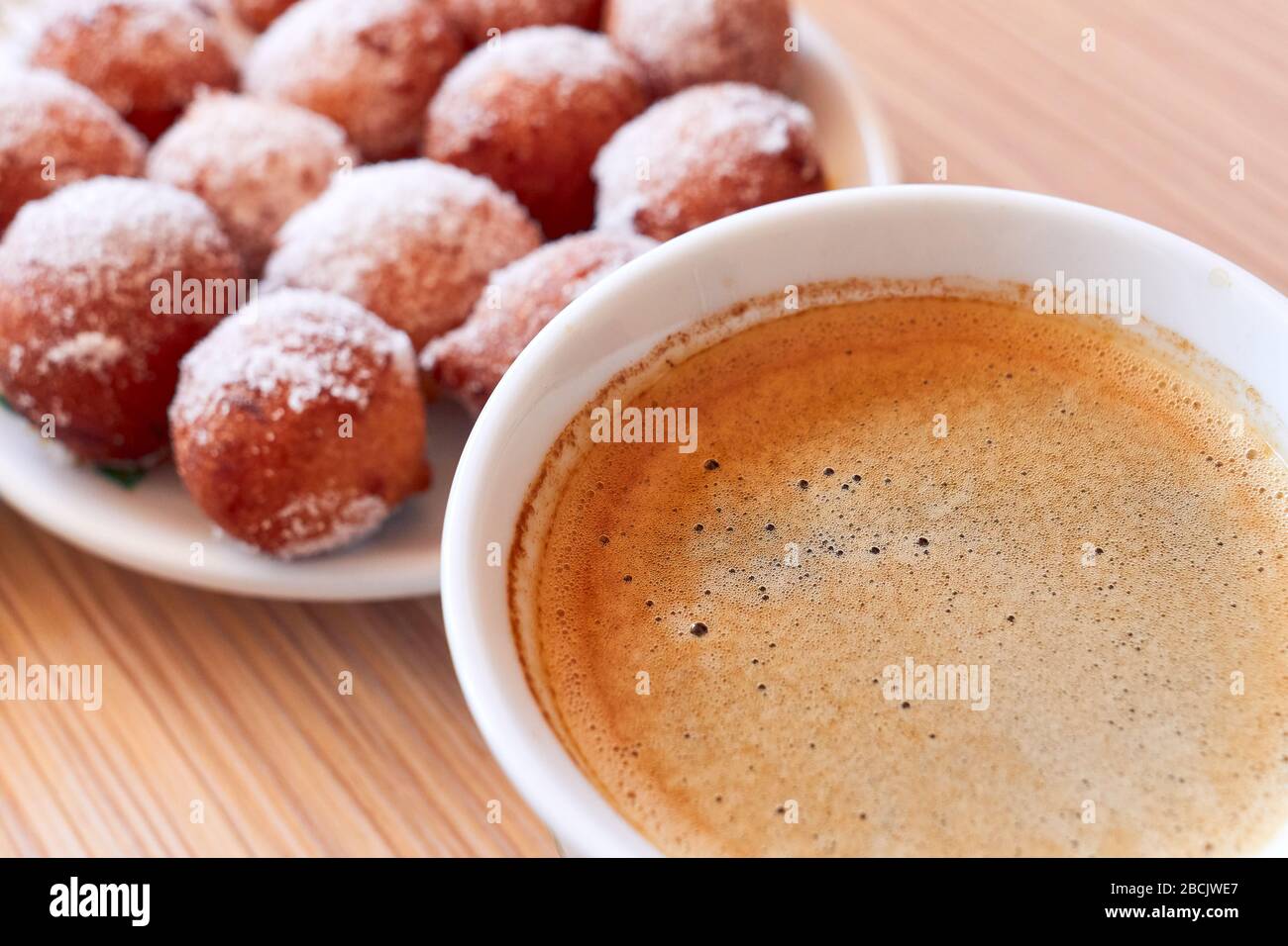 Starting morning with a coffee and homemade donut holes during pandemic isolation Stock Photo