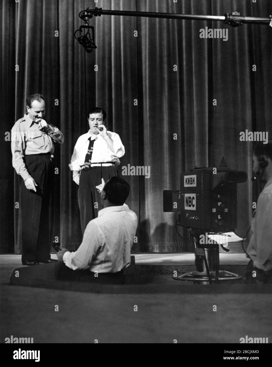 BUD ABBOTT and LOU COSTELLO with Director circa 1953 on set candid filming THE ABBOTT AND COSTELLO SHOW TV Series 1952-1957 for Television Corporation of America / National Broadcasting Corporation (NBC) Stock Photo